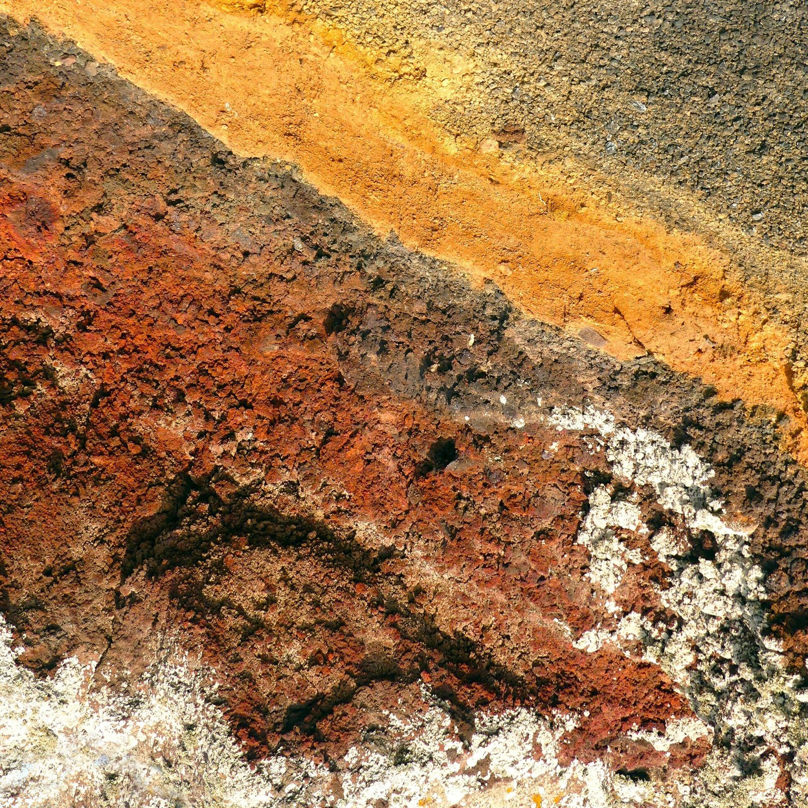 Close-up of a colorful, textured rock surface with geological layers in Greece.